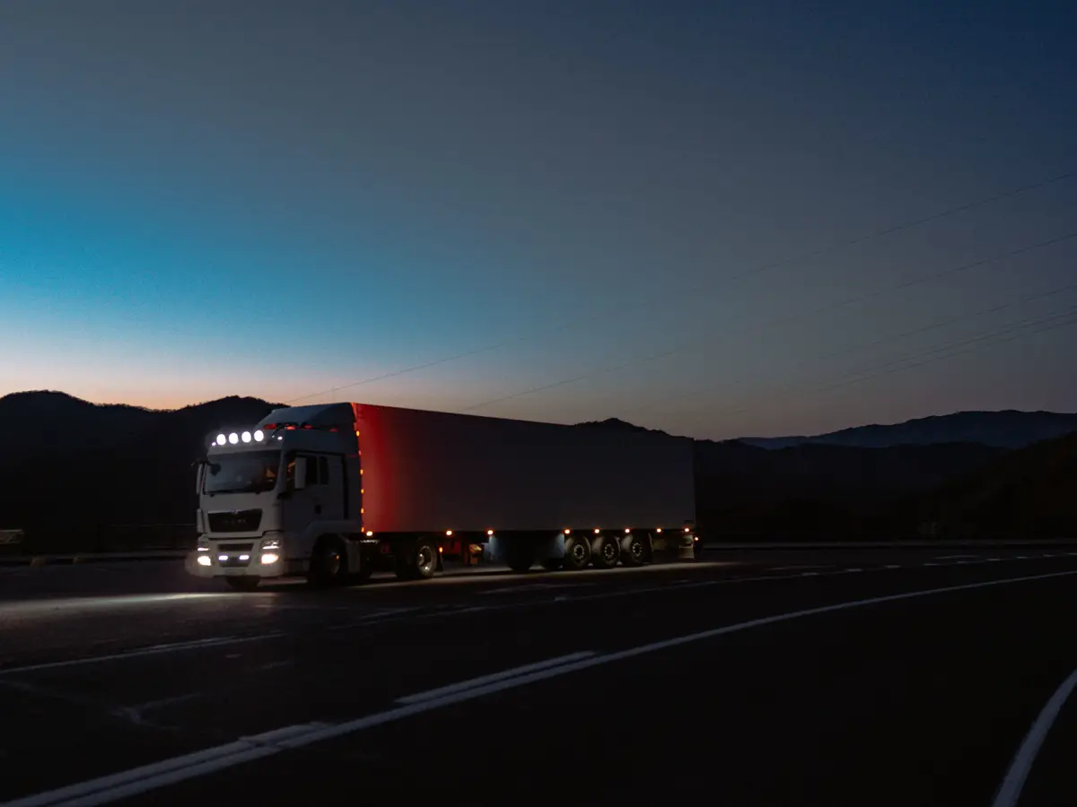 Semi truck with lights on at dusk