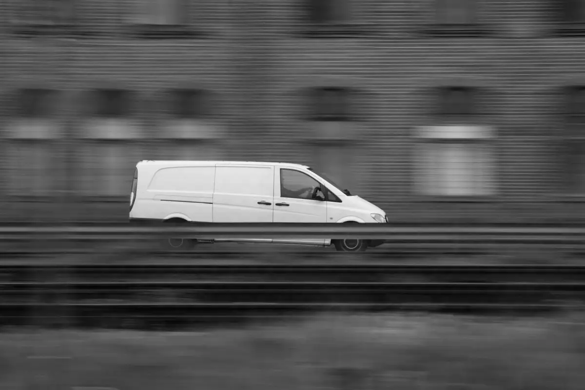 White delivery van in motion on a city street